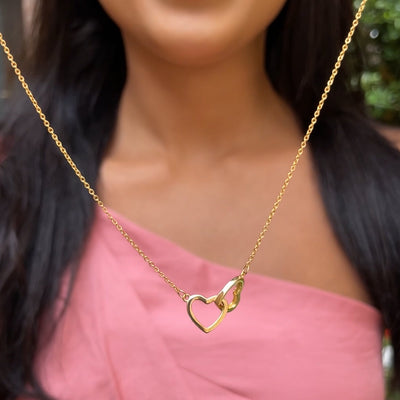 Collana dorata a doppio cuore indossata